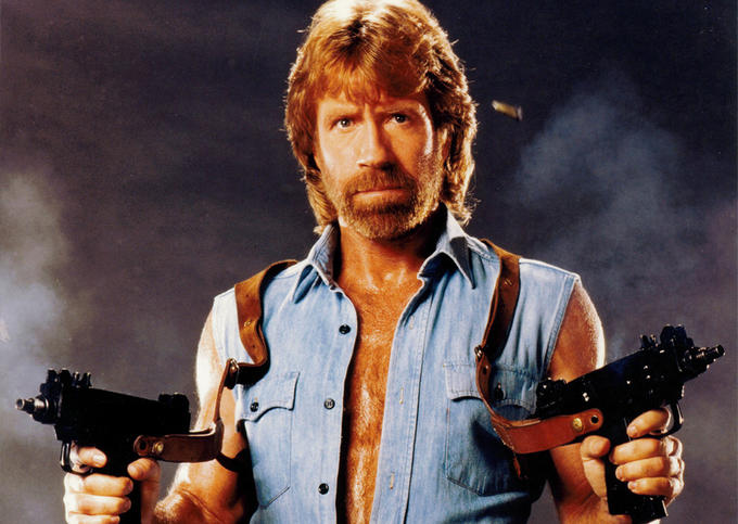 Classic Chuck Norris pose with 2 Uzi submachine guns drawn and firing